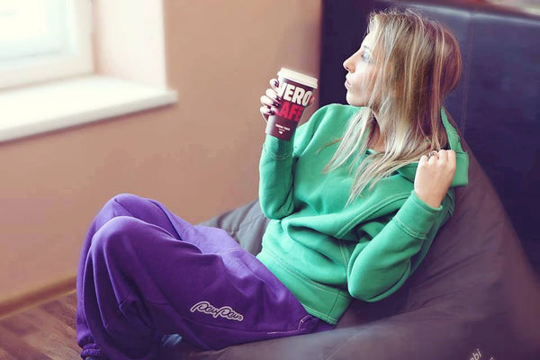 A person wearing baggy purple sweatpants while lounging at home.